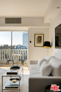 a living room with furniture and a floor to ceiling window