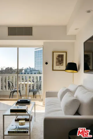 a living room with furniture and a floor to ceiling window