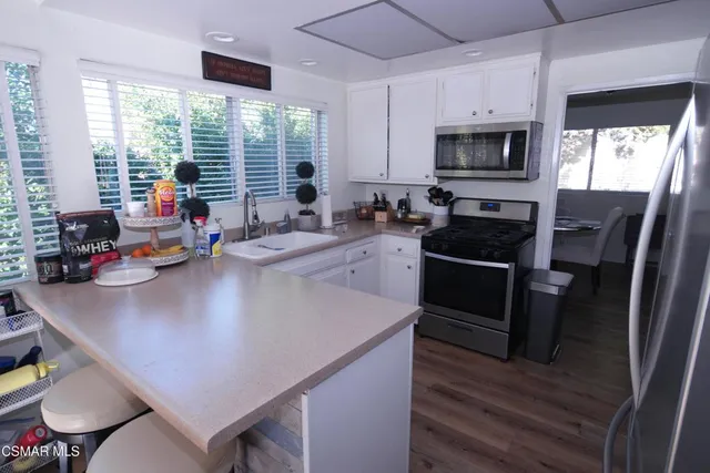 a kitchen with stainless steel appliances granite countertop a sink a stove and a refrigerator
