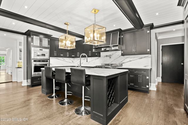 a kitchen with kitchen island granite countertop a sink cabinets and stainless steel appliances