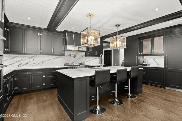 a kitchen with granite countertop a sink stainless steel appliances and cabinets