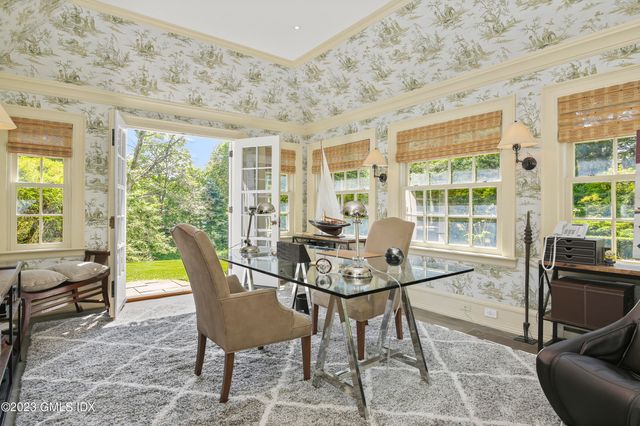 a view of a dining room with furniture large windows and wooden floor