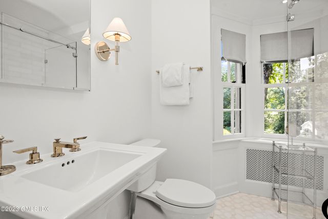 a bathroom with a sink a toilet and shower