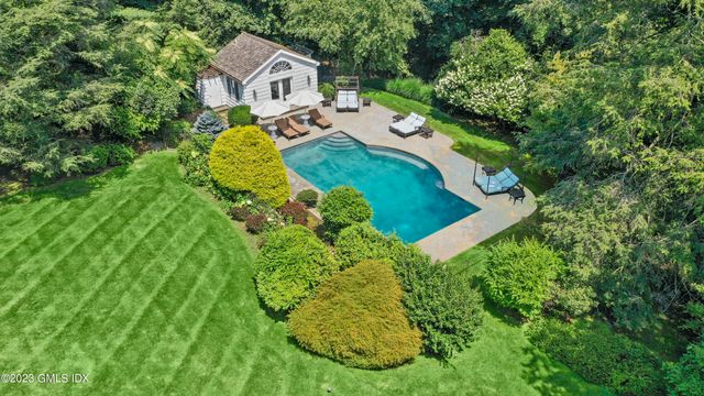 a aerial view of a house with a yard and large trees