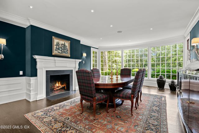 a dining room with furniture a fireplace and wooden floor