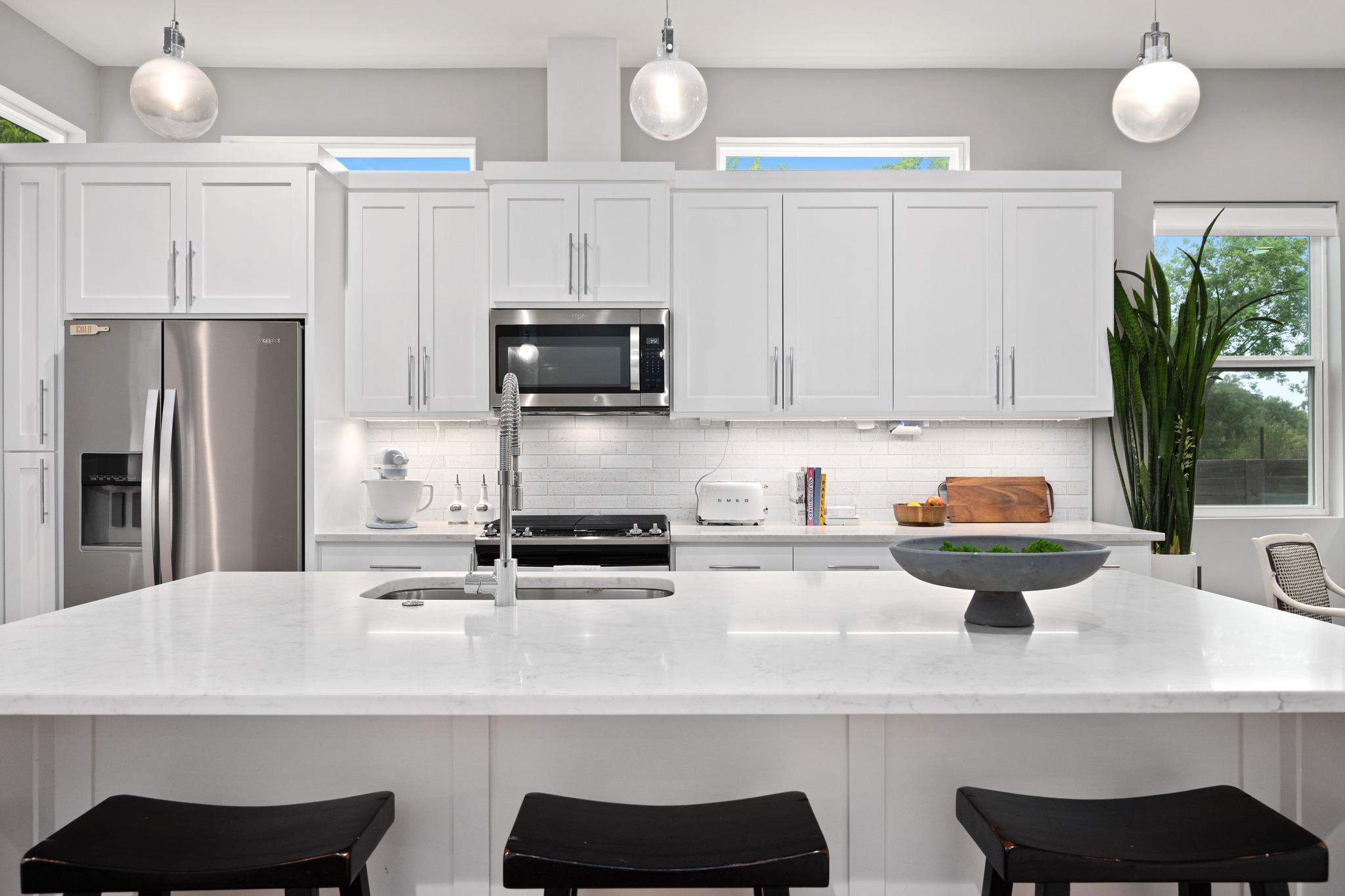 1103 Saucedo Street, Unit 1 Austin, TX 78721 - Photo 18 of 40 White cabinetry and stone counters define this well-appointed contemporary kitchen.