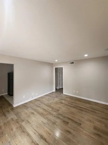 a view of an empty room with wooden floor