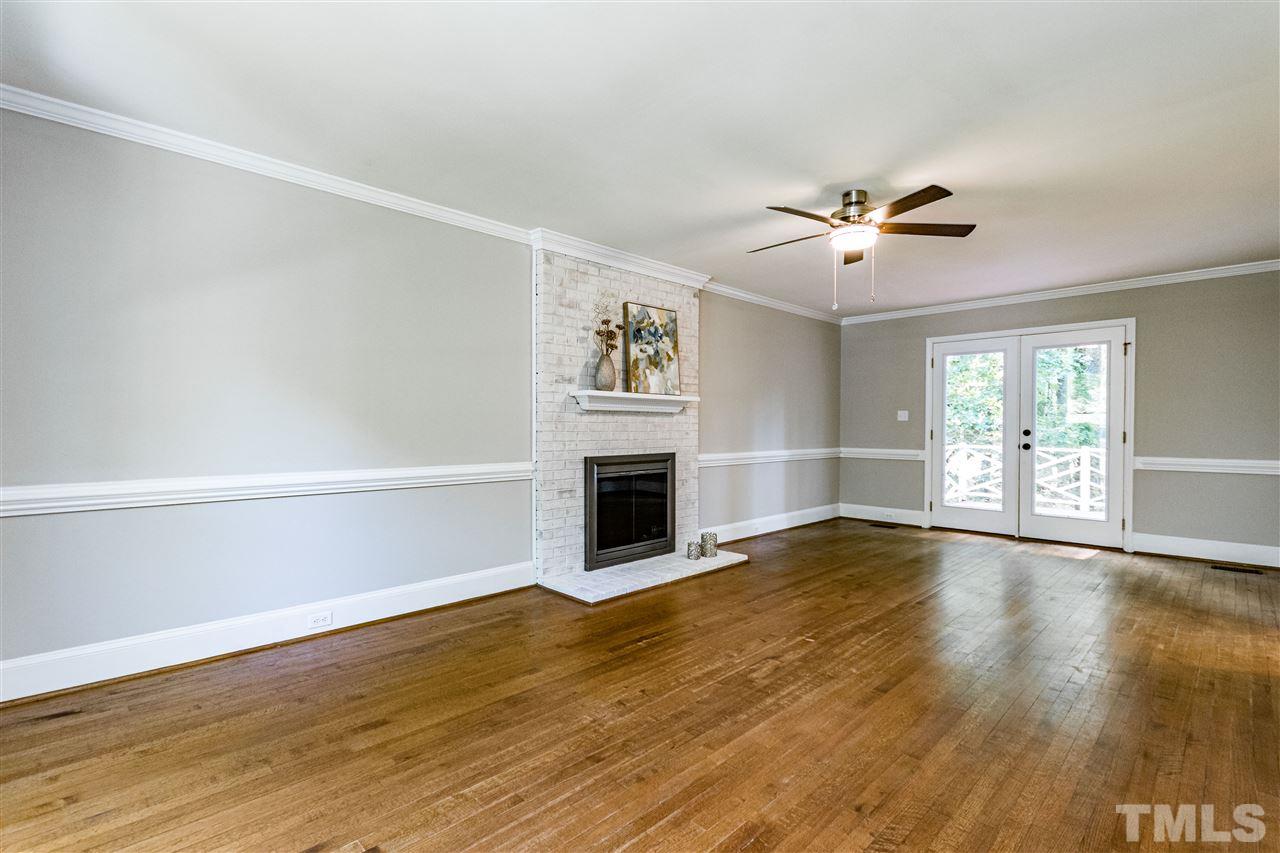 7301 Quinby Court Raleigh, NC 27613 - Photo 11 of 23 Lime washed brick wood burning fireplace and hardwood floors. Huge room.