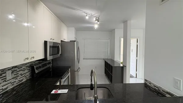 a kitchen with a sink and a stove top oven