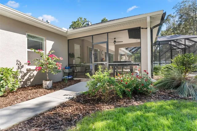 a view of a patio with table and chairs potted plants and floor to ceiling window