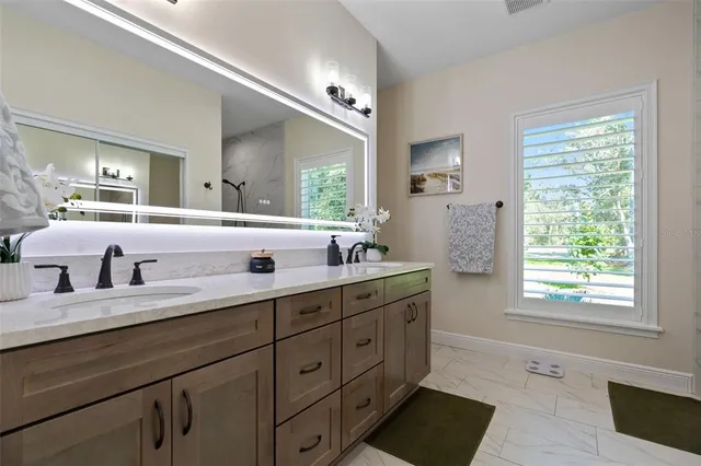 a bathroom with a granite countertop sink a mirror a shower and a bathtub
