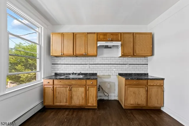 a view of a kitchen with wooden floor and a sink