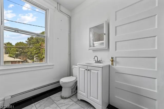 a bathroom with a sink toilet and window