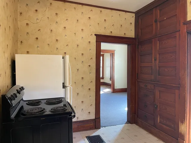a kitchen with a wooden floor and cabinets