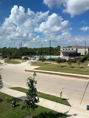 a view of swimming pool with outdoor seating and yard in back