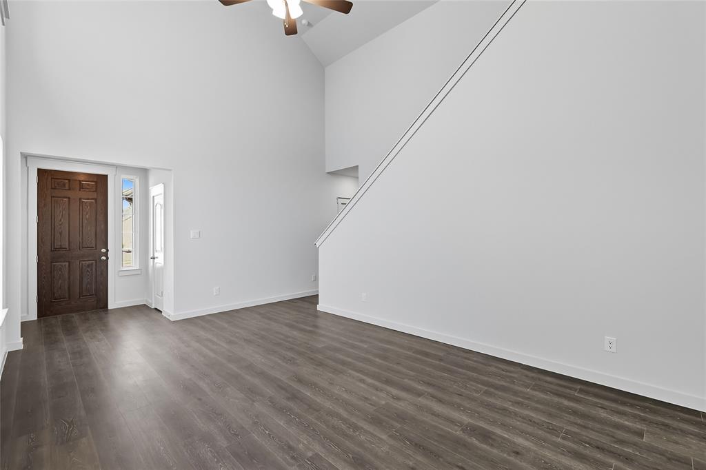 519 Martell Road Lowry Crossing, TX 75407 - Photo 9 of 35 a view of an empty room with wooden floor and a ceiling fan