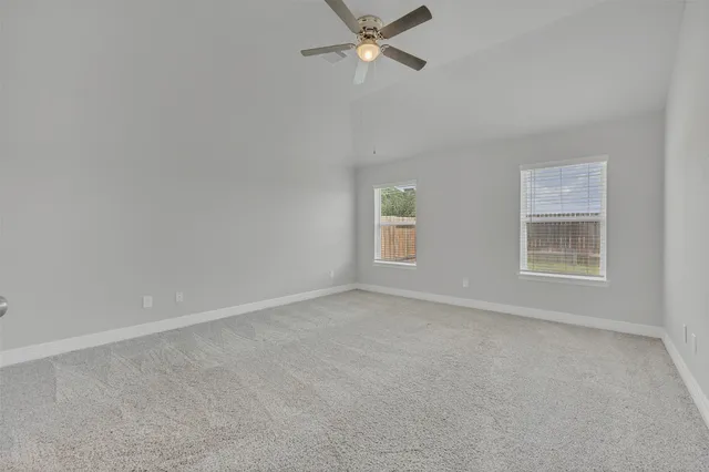 an empty room with a window and a fan