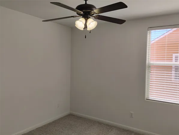an empty room with a chandelier fan and a chandelier fan