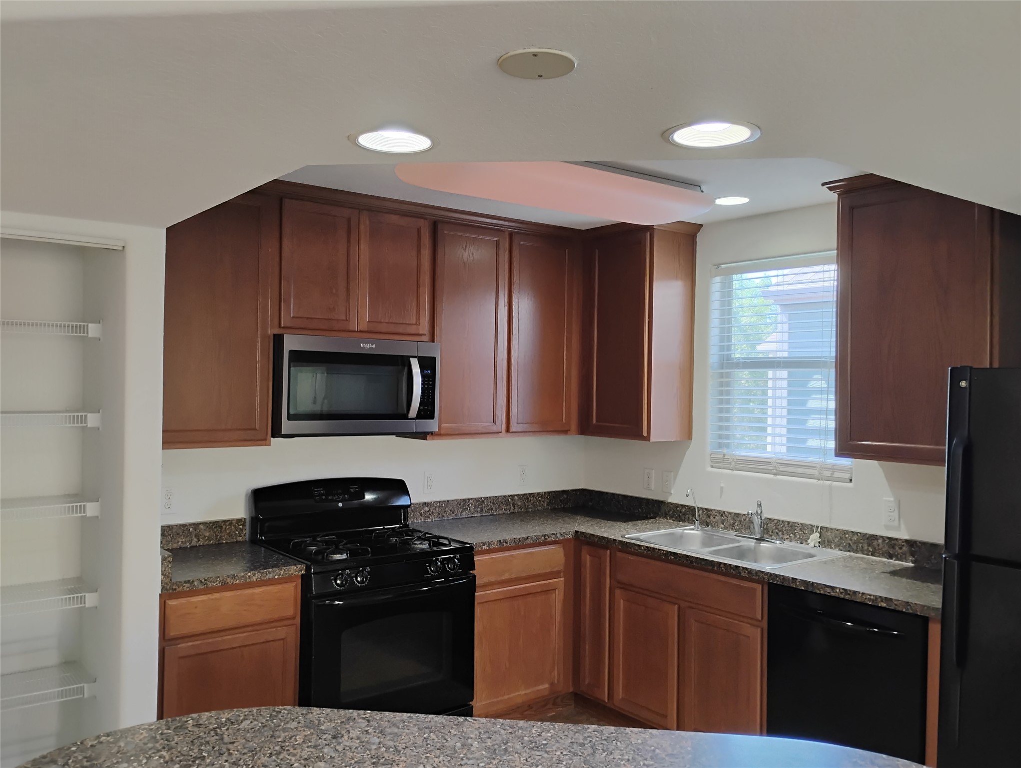 254 Trestle Tree, Unit AB San Marcos, TX 78666 - Photo 9 of 19 a kitchen with granite countertop wooden cabinets and a stove top oven
