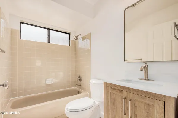 a bathroom with a bathtub shower sink vanity and toilet