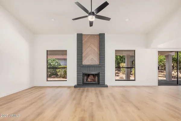 a view of an empty room with a fireplace and a window