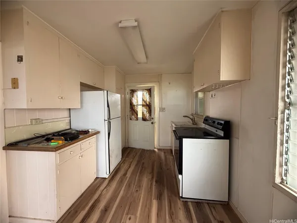 a kitchen with stainless steel appliances a refrigerator a sink a stove and white cabinets