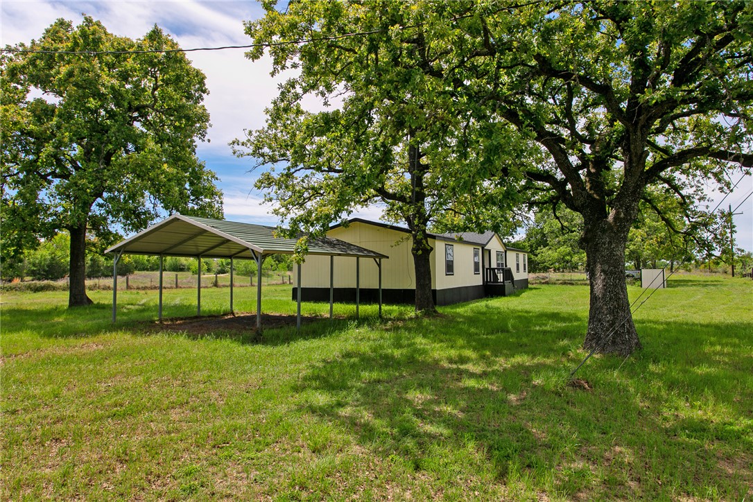 11459 Winstead Lane Calvert, TX 77837 - Photo 30 of 37 a white house with a big yard and large trees