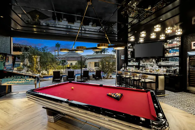 a view of a swimming pool with couches chairs in patio