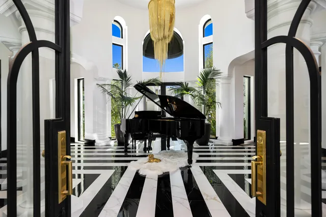 a living room with furniture a chandelier and kitchen view