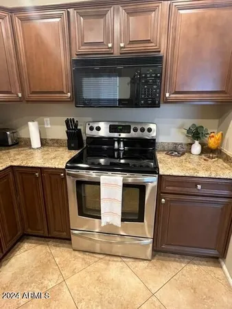 a kitchen with granite countertop a stove and a microwave