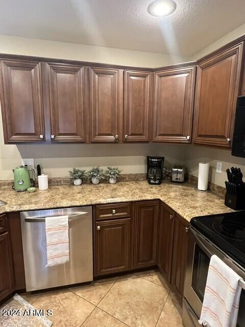 8700 East Mountain View Road, Unit 1058 Scottsdale, AZ 85258 - Photo 10 of 31 a kitchen with stainless steel appliances granite countertop a stove a sink dishwasher and cabinets with wooden floor