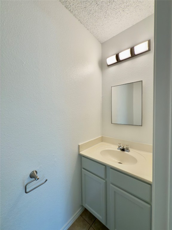 7817 Marble Ridge Drive Austin, TX 78747 - Photo 19 of 38 Bathroom featuring a textured ceiling, vanity, and tile patterned floors