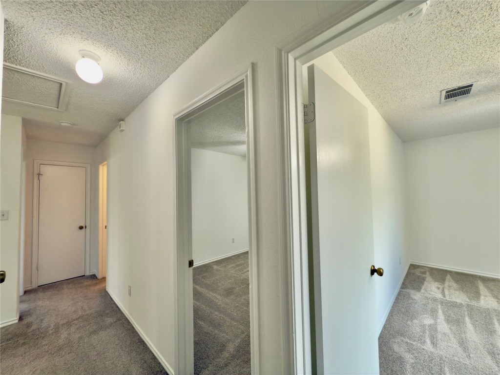 7817 Marble Ridge Drive Austin, TX 78747 - Photo 24 of 38 Hall with a textured ceiling, carpet floors, and baseboards