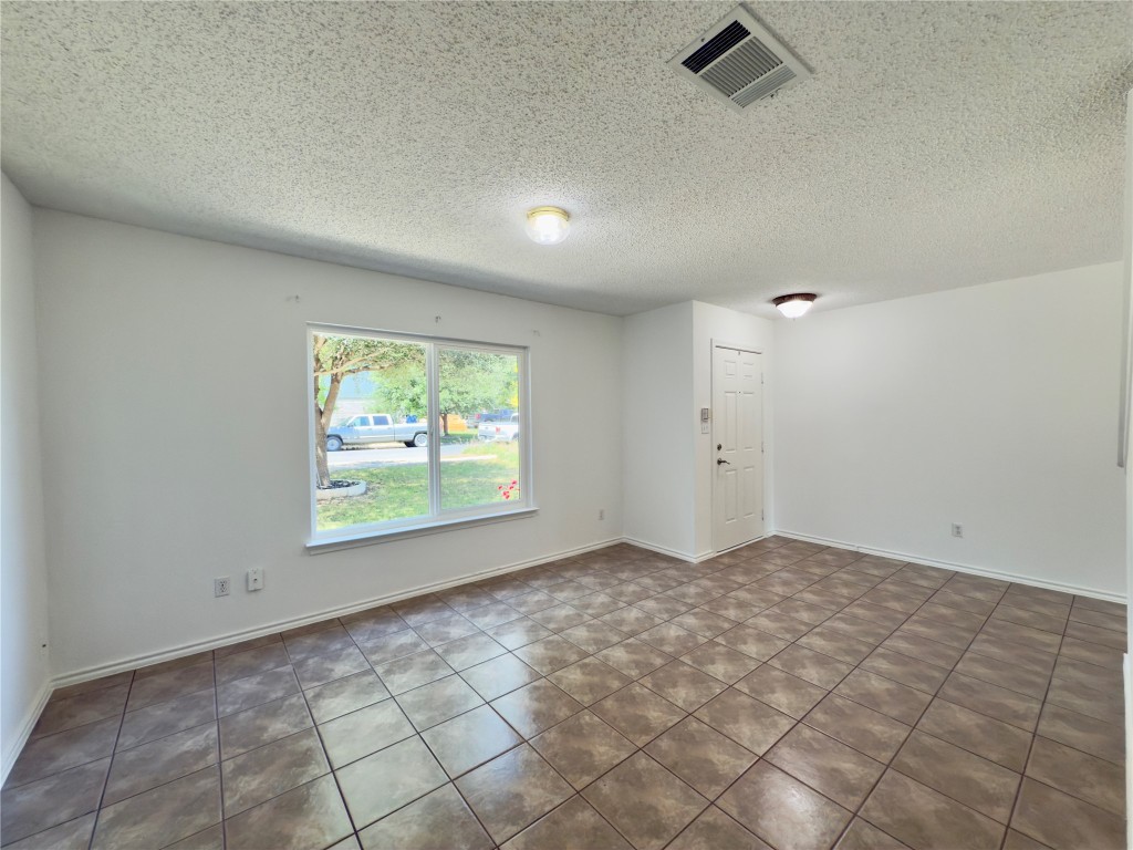 7817 Marble Ridge Drive Austin, TX 78747 - Photo 9 of 38 Tiled spare room with a textured ceiling and baseboards