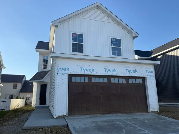 a front view of a house with yard and garage