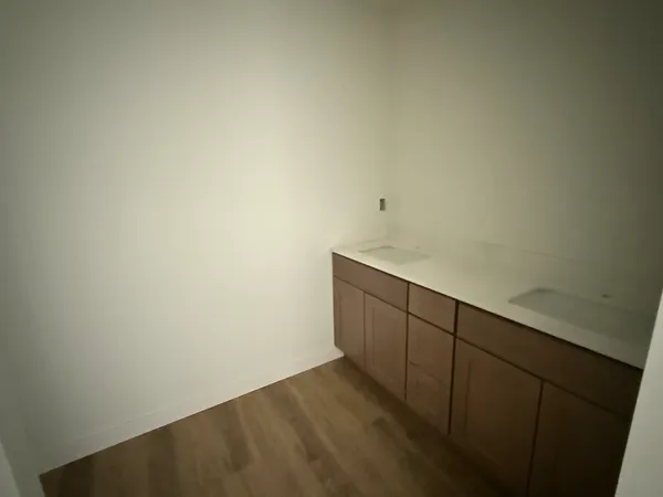 an empty room with wooden floor and window