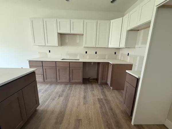 a kitchen with cabinets and wooden floor
