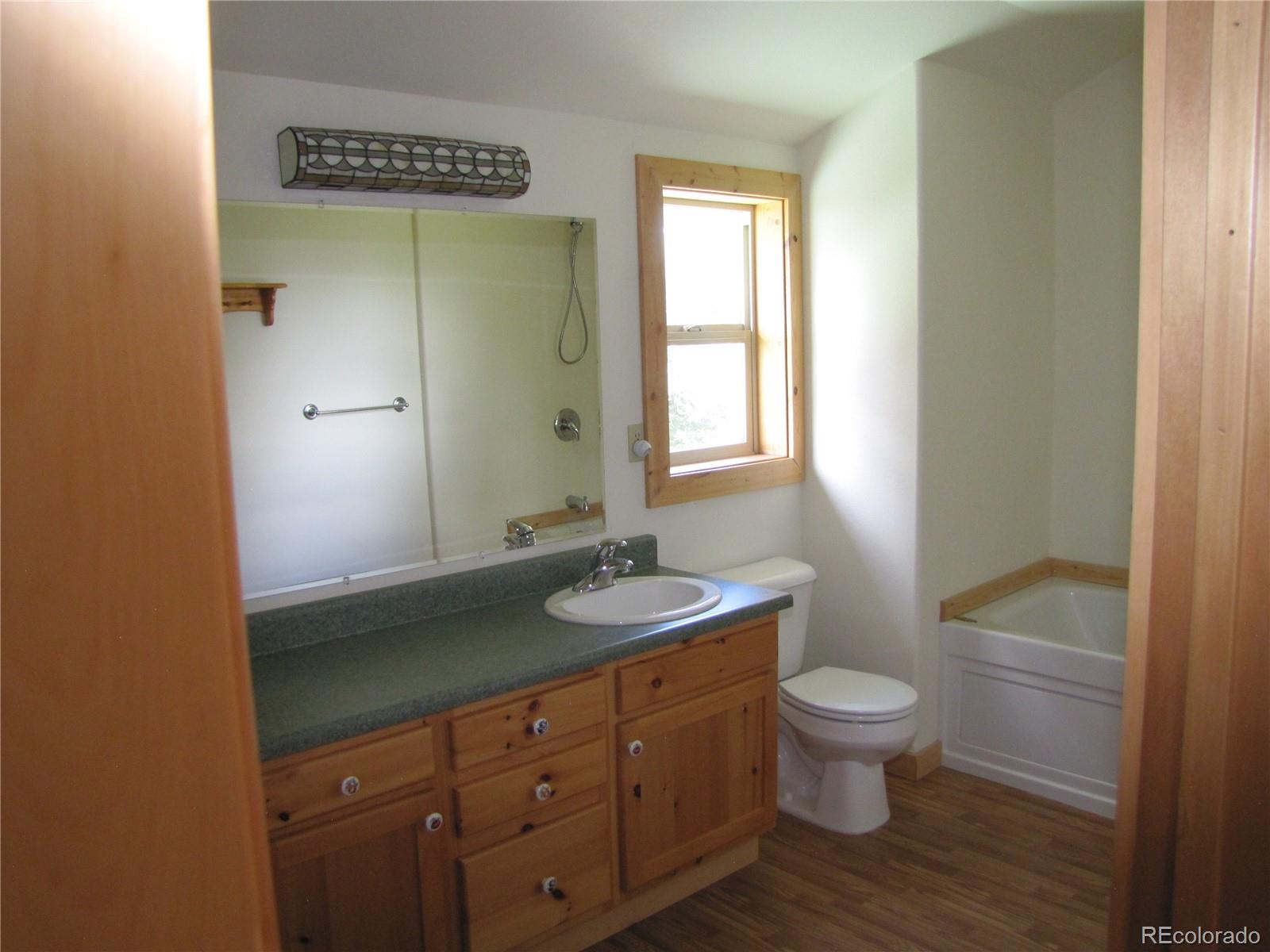 1240 Campfire Road Hartsel, CO 80449 - Photo 14 of 25 a bathroom with a granite countertop sink toilet and mirror