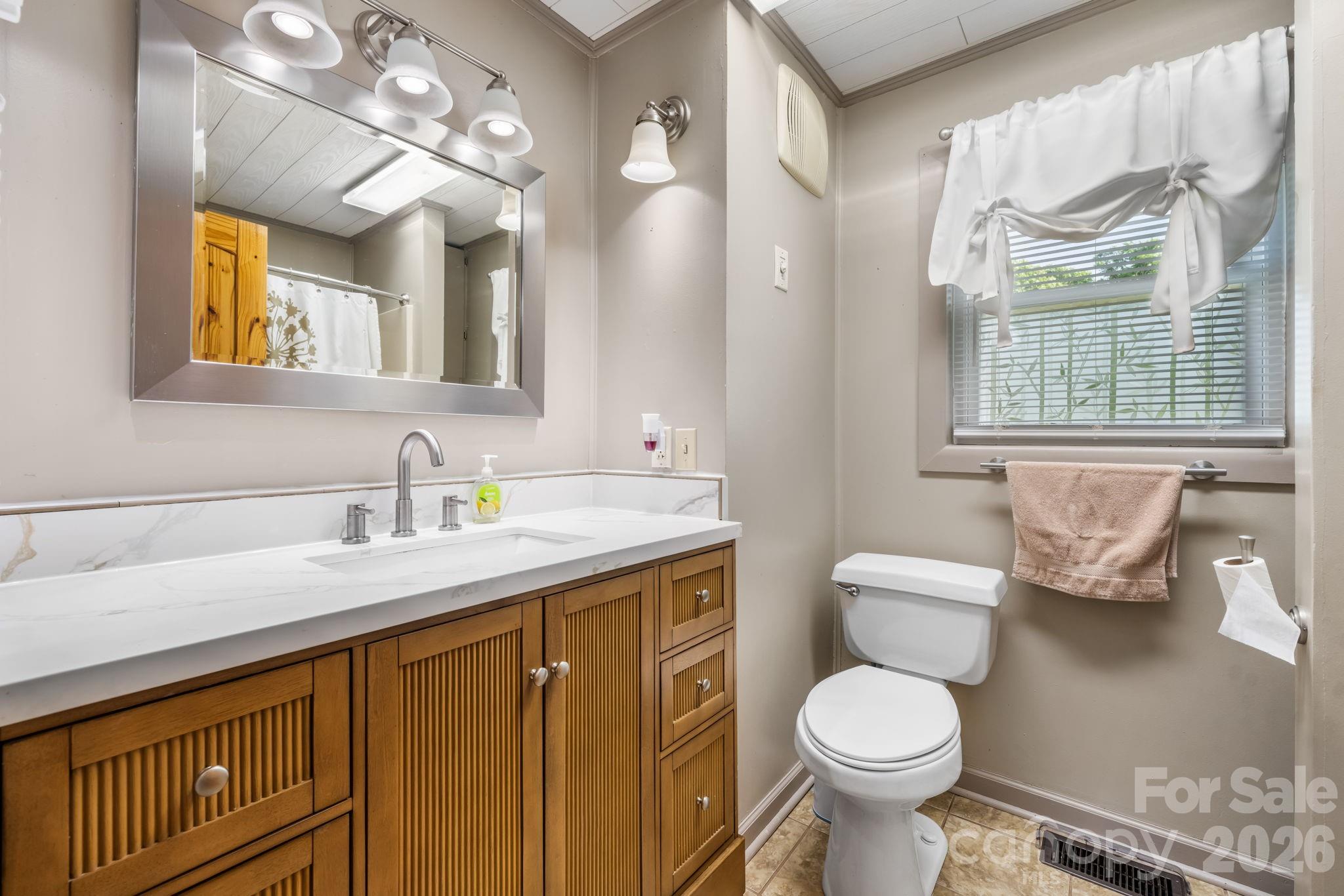 2582 Startown Road Newton, NC 28658 - Photo 14 of 42 a bathroom with a granite countertop toilet sink and mirror