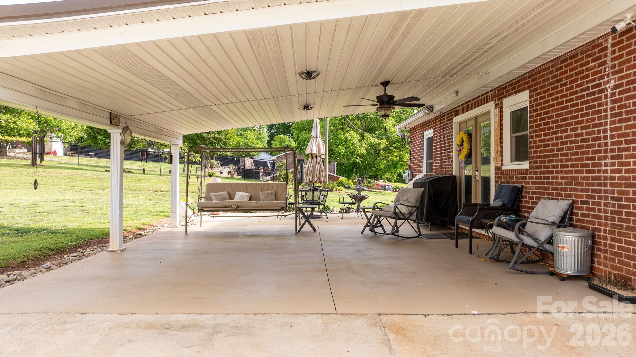 2582 Startown Road Newton, NC 28658 - Photo 22 of 42 a view of a patio with table and chairs potted plants with floor to ceiling window