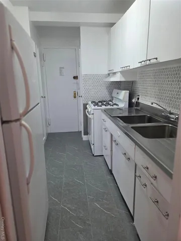 a kitchen with a sink a refrigerator and cabinets