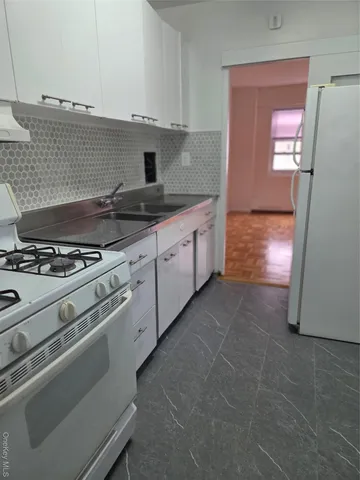 a kitchen with granite countertop a stove and a refrigerator