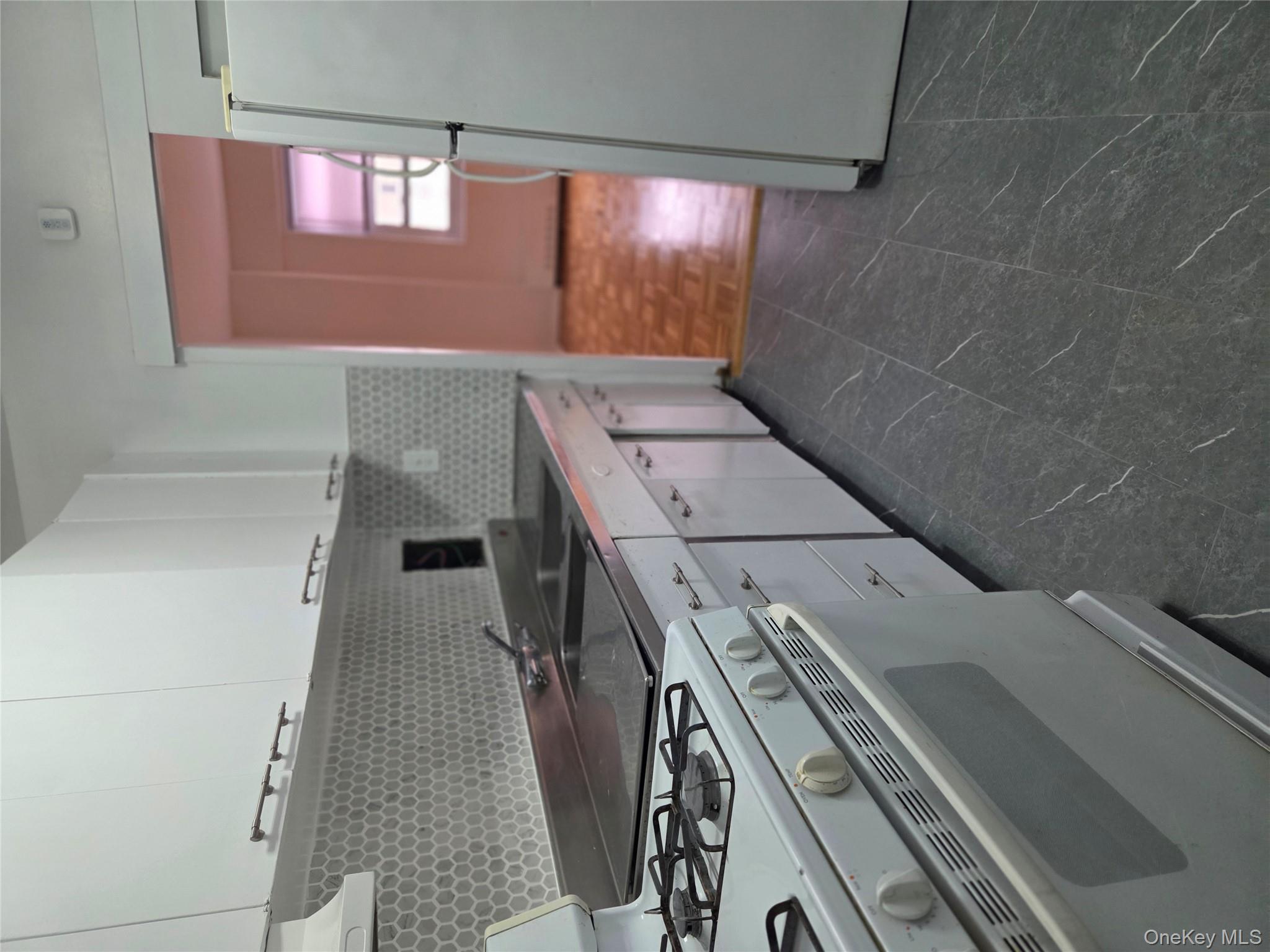 7 Fordham Hill Ovl, Unit 12G Bronx, NY 10468 - Photo 7 of 18 a kitchen with granite countertop a stove and a refrigerator