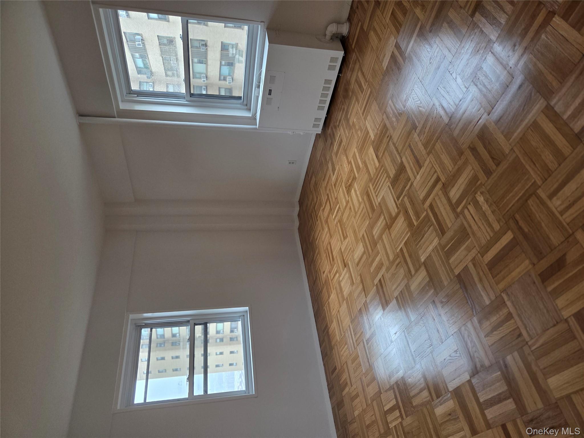 7 Fordham Hill Ovl, Unit 12G Bronx, NY 10468 - Photo 9 of 18 a view of an empty room with wooden floor and a window
