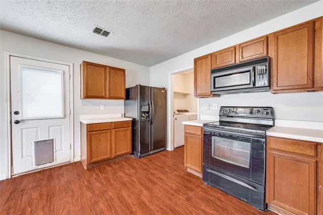 a kitchen with stainless steel appliances granite countertop a refrigerator stove and sink