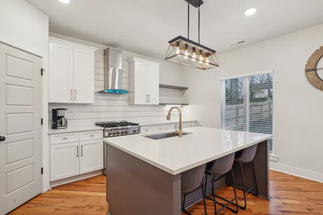 a kitchen with a table chairs and white cabinets