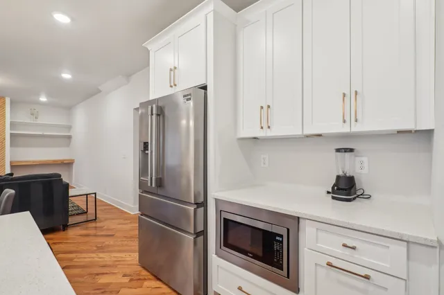 a kitchen with stainless steel appliances white cabinets and a refrigerator