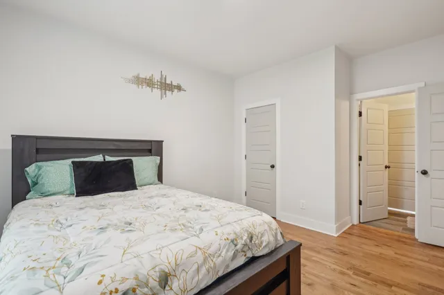 a bedroom with a bed and wooden floor