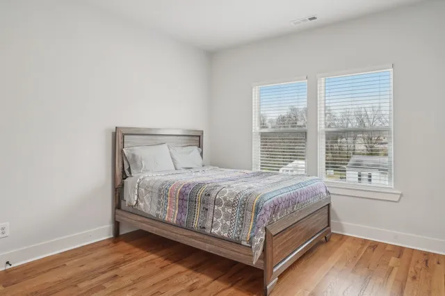a bed sitting in a bedroom next to a window