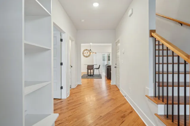a view of a hallway with wooden floor and furniture